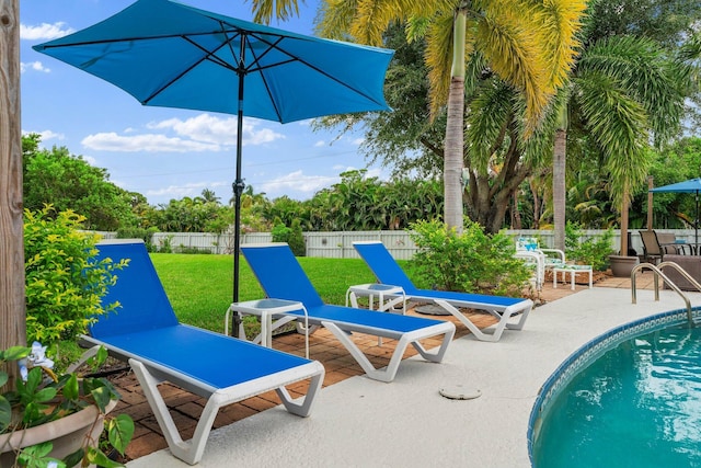 view of pool featuring a fenced in pool, a patio, a lawn, and fence