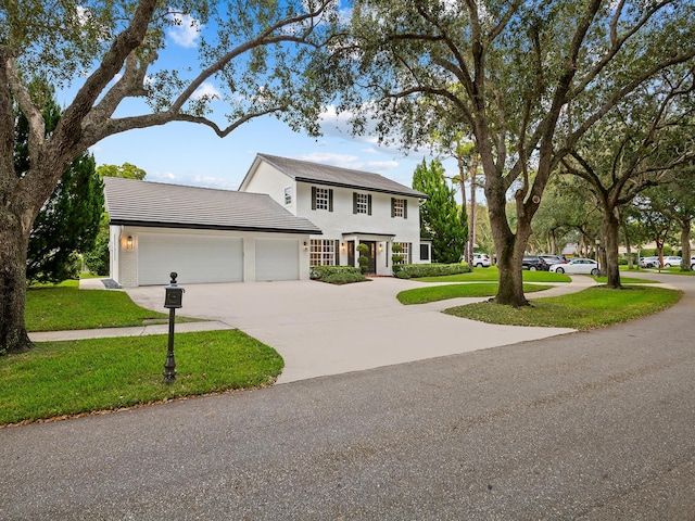 colonial home featuring a garage and a front lawn