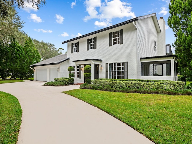 colonial home with a garage and a front yard