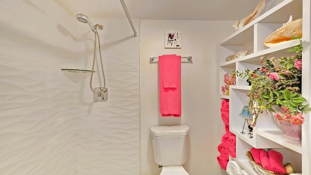 bathroom with toilet and tiled shower