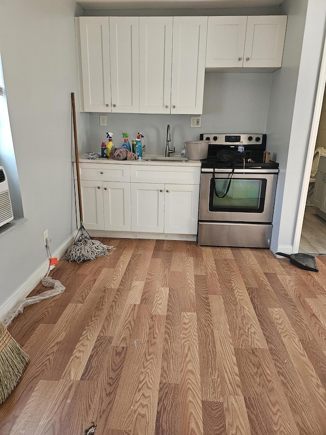 kitchen with white cabinetry, sink, stainless steel range with electric cooktop, and light wood-type flooring