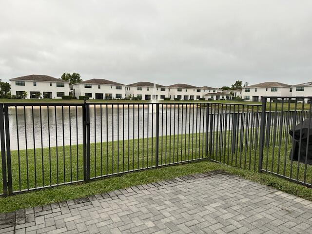 view of gate featuring a water view and a yard