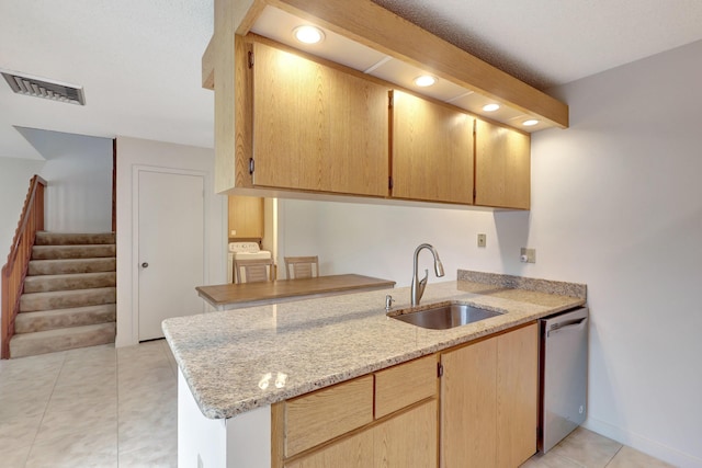 kitchen with light tile patterned flooring, sink, kitchen peninsula, dishwasher, and light stone countertops