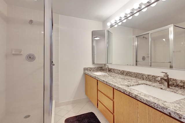 bathroom featuring tile patterned floors, an enclosed shower, and vanity