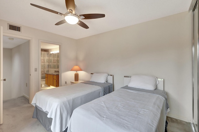 carpeted bedroom featuring ensuite bath and ceiling fan