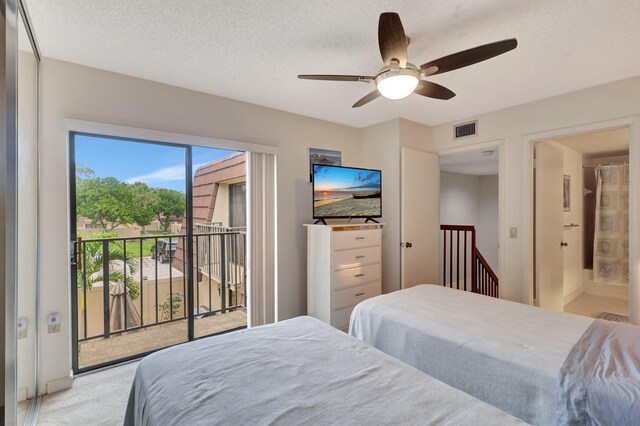 bedroom featuring ceiling fan, access to exterior, ensuite bathroom, a textured ceiling, and light colored carpet