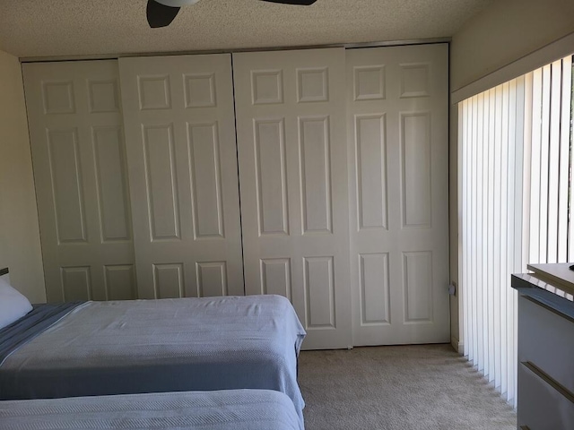 bedroom featuring light colored carpet, a closet, and a textured ceiling