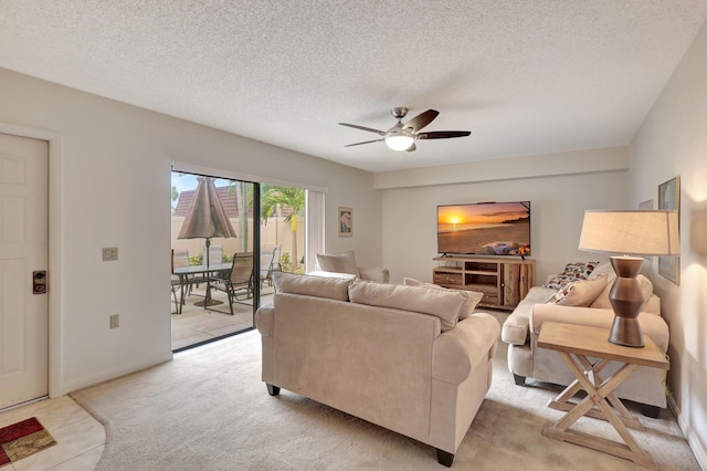 living room featuring light carpet, ceiling fan, and a textured ceiling