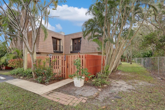 view of front of house featuring a front lawn and a balcony