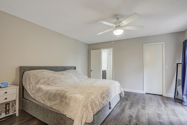 bedroom featuring ceiling fan, dark wood-type flooring, and a textured ceiling