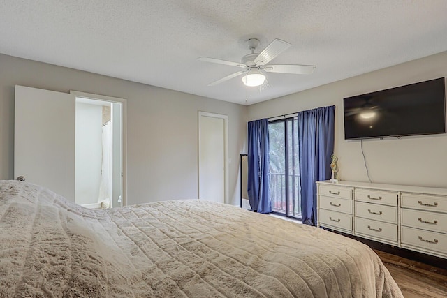 bedroom with ceiling fan, dark wood-type flooring, and a textured ceiling