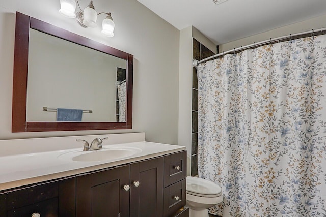 bathroom with toilet, vanity, and curtained shower