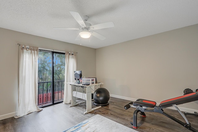 exercise area with hardwood / wood-style flooring, ceiling fan, and a textured ceiling