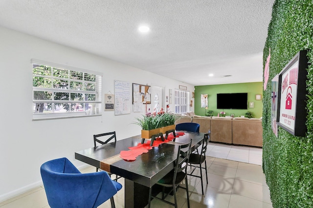 tiled dining space with a textured ceiling