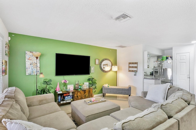 tiled living room featuring a textured ceiling