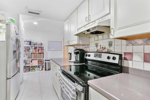 kitchen with backsplash, light tile patterned floors, stainless steel appliances, and white cabinets