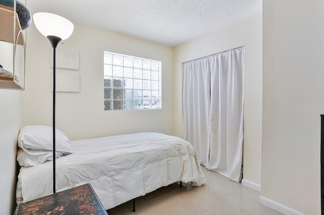 bedroom featuring a textured ceiling and light tile patterned floors