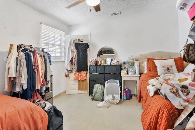 tiled bedroom featuring ceiling fan and a textured ceiling