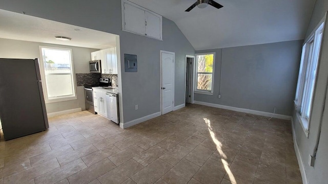 kitchen featuring lofted ceiling, ceiling fan, appliances with stainless steel finishes, white cabinetry, and decorative backsplash