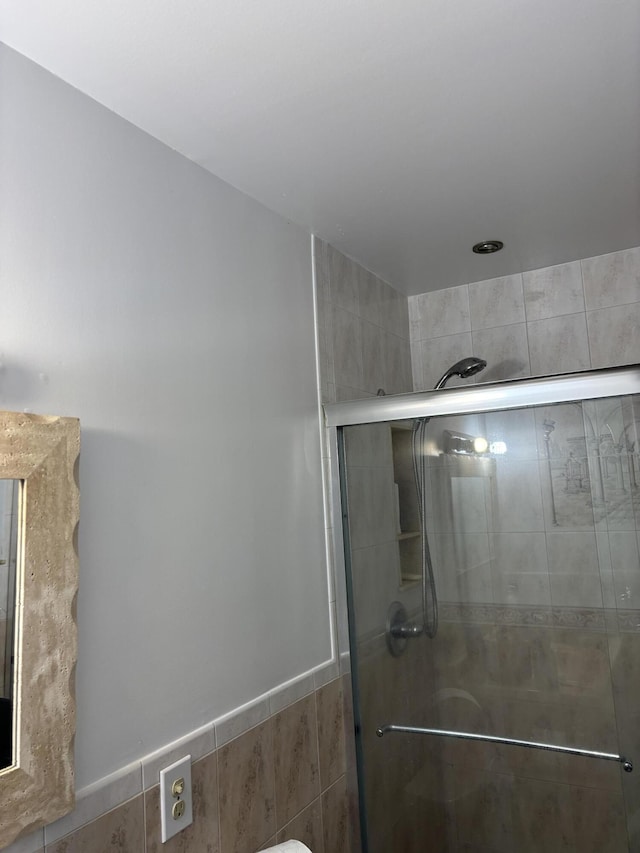 bathroom featuring tile walls and walk in shower