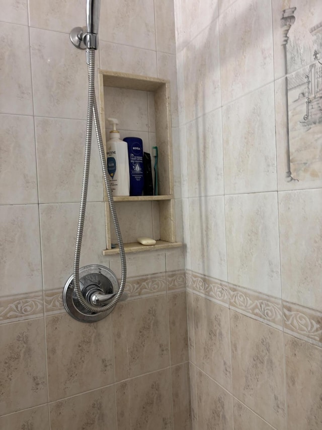 interior details featuring a tile shower