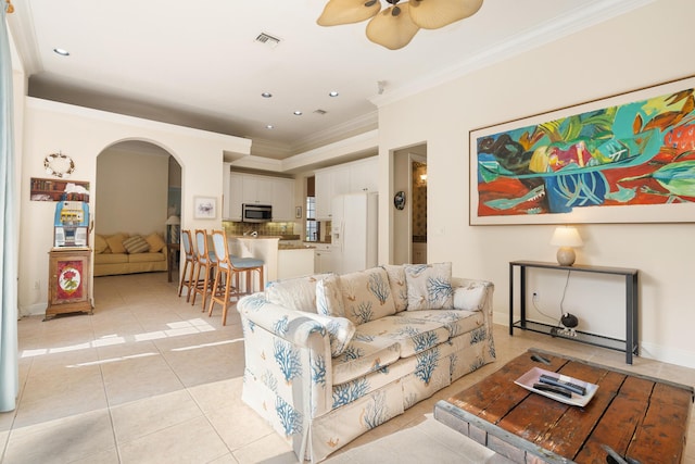 tiled living room featuring ceiling fan and ornamental molding