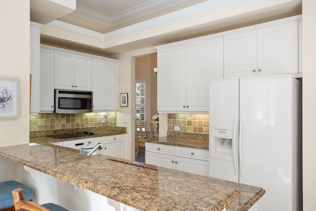 kitchen featuring kitchen peninsula, white fridge with ice dispenser, and white cabinets