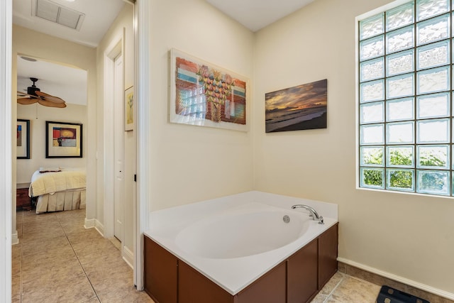 bathroom with ceiling fan, a tub to relax in, and tile patterned flooring