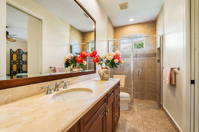 bathroom featuring a shower with door, ceiling fan, vanity, tile patterned floors, and toilet