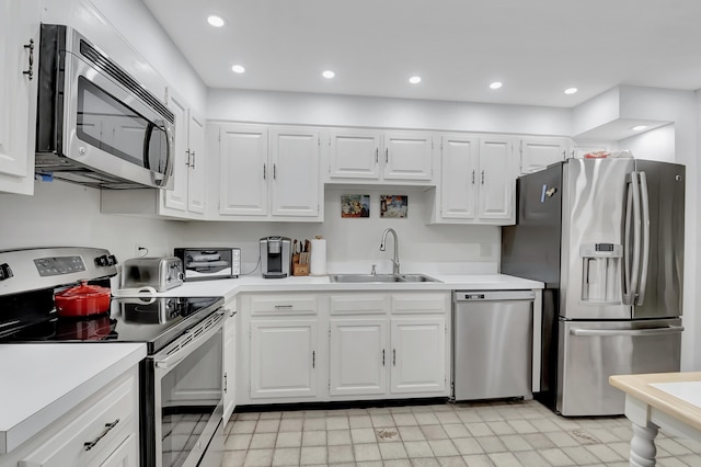 kitchen featuring stainless steel appliances, sink, and white cabinets