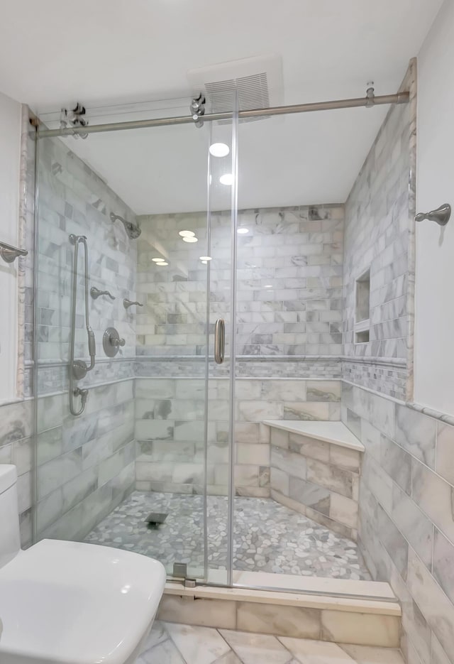 bathroom featuring an enclosed shower and tile walls