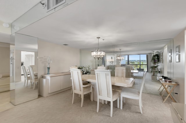 dining room featuring light carpet and a notable chandelier