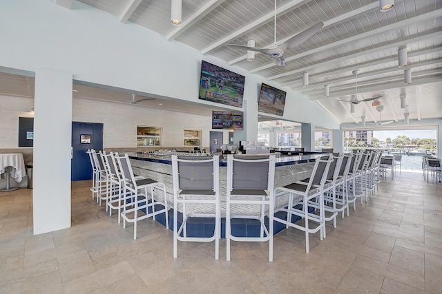 interior space featuring ceiling fan, beam ceiling, and high vaulted ceiling