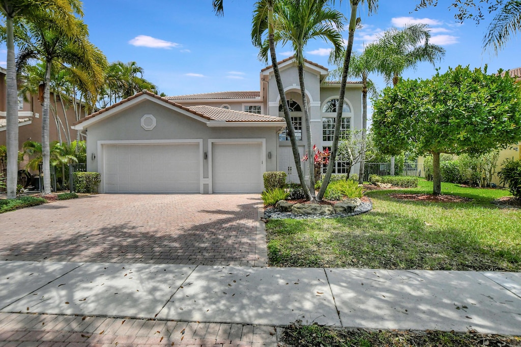 mediterranean / spanish-style home with a garage and a front yard