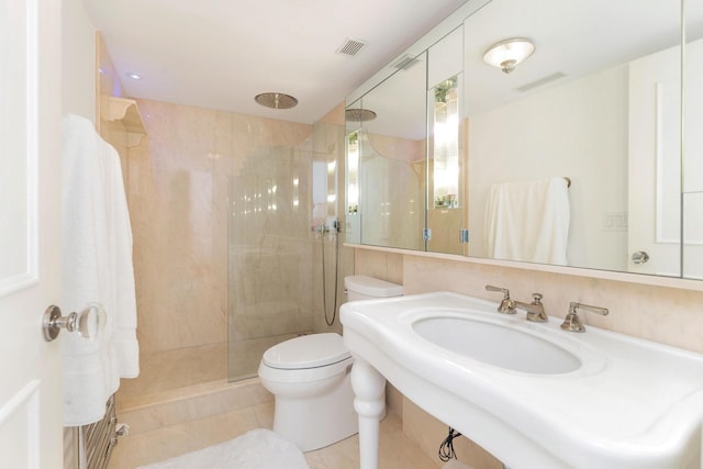 bathroom with tiled shower and toilet