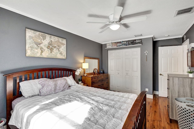 bedroom featuring a closet, ornamental molding, dark hardwood / wood-style floors, and ceiling fan