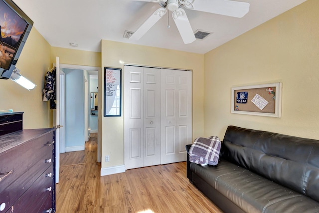 living room featuring ceiling fan and light hardwood / wood-style flooring