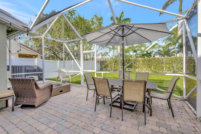 view of patio featuring glass enclosure