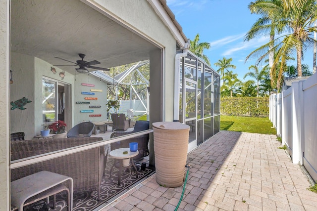 view of patio / terrace with ceiling fan and glass enclosure