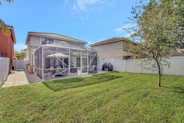 back of house with a yard, a lanai, and a patio area