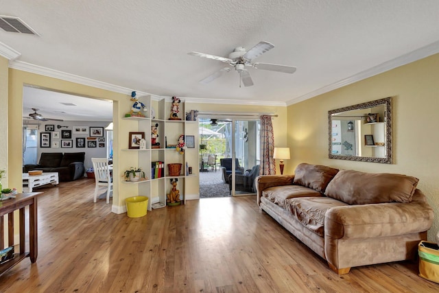 living room featuring crown molding, ceiling fan, and light hardwood / wood-style flooring