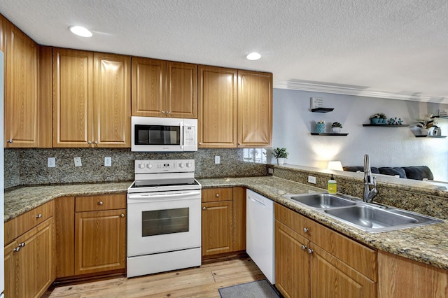 kitchen with white appliances, light hardwood / wood-style floors, sink, and backsplash