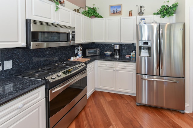 kitchen featuring stainless steel appliances, white cabinets, and decorative backsplash