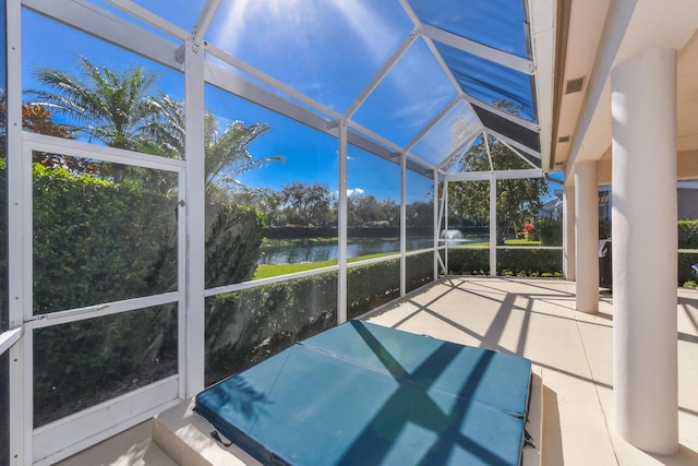 sunroom featuring a water view