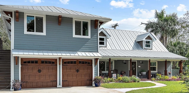 view of front of home with a porch, a garage, and a front yard