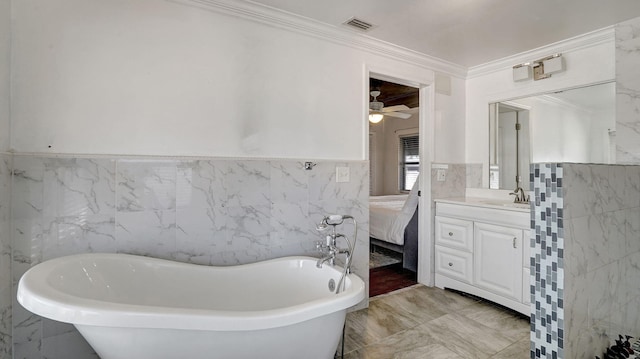 bathroom featuring crown molding, vanity, a bathtub, and tile walls