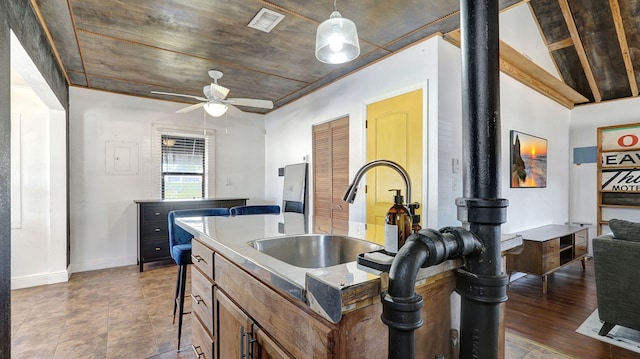 kitchen featuring sink, hanging light fixtures, ceiling fan, and a kitchen island