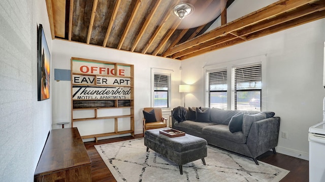 living room with dark hardwood / wood-style floors and lofted ceiling with beams