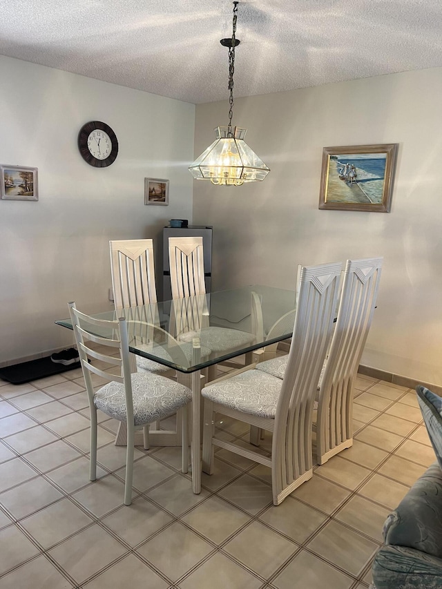 dining area featuring a textured ceiling and light tile patterned floors