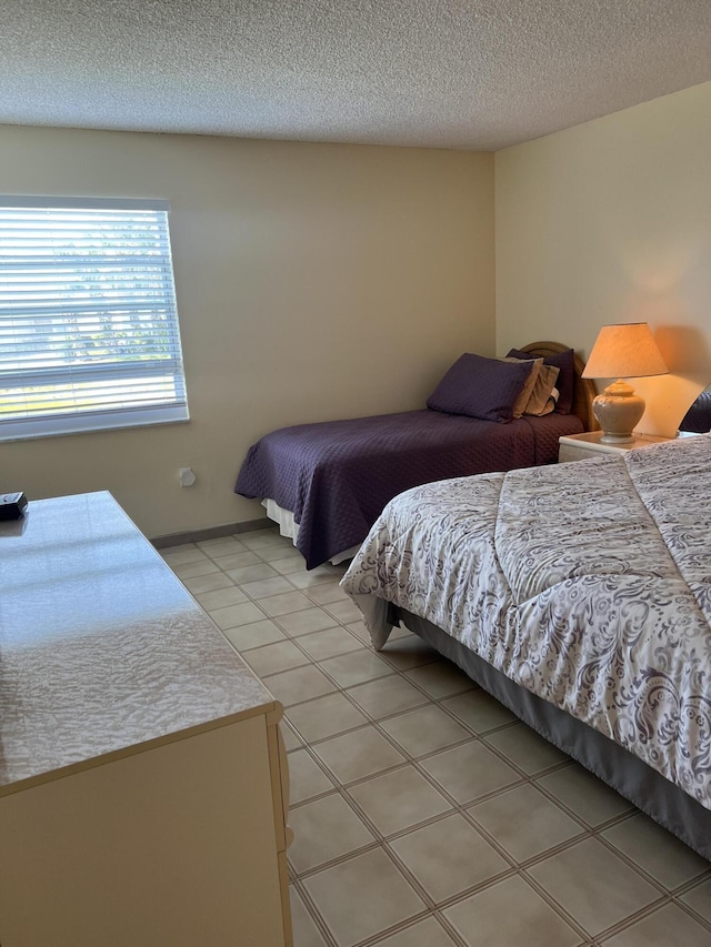 bedroom featuring a textured ceiling and light tile patterned flooring